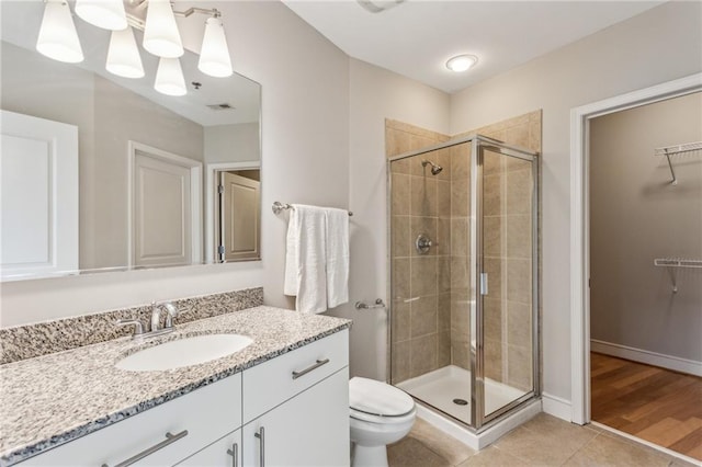 bathroom with an enclosed shower, vanity, tile patterned flooring, and toilet