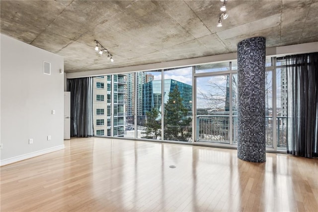 empty room with wood-type flooring and floor to ceiling windows