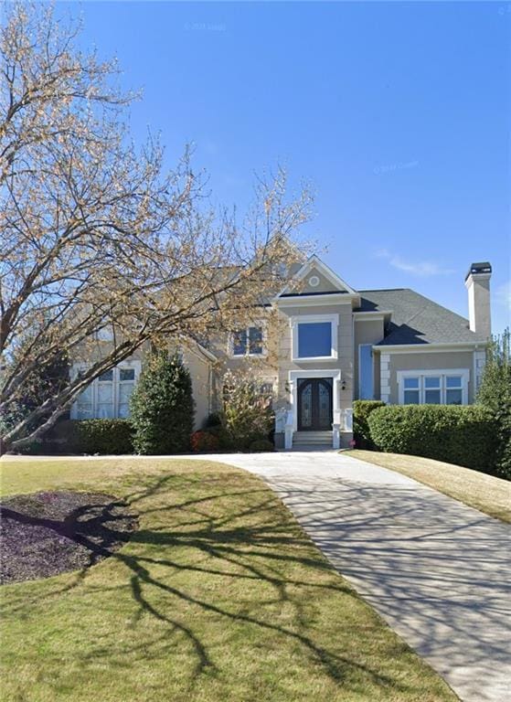 12120 Meadows Ln, Alpharetta, GA 30005 - view of front of property featuring a chimney, a front yard, and french doors