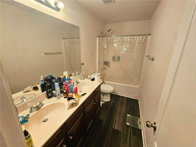 full bath featuring toilet, wood finished floors, double vanity, and shower / bath combo