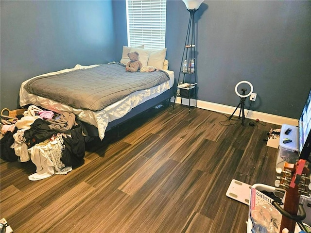 bedroom with wood finished floors and baseboards