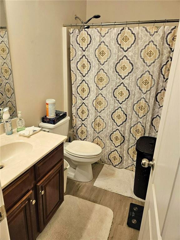 full bathroom featuring wood finished floors, vanity, toilet, and a shower with curtain
