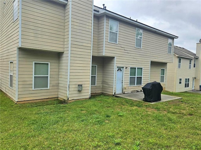 back of property featuring a patio area and a yard