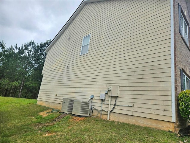 view of home's exterior featuring central air condition unit and a yard