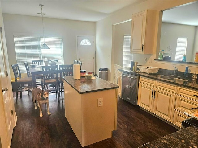 kitchen with dishwasher, a sink, dark wood finished floors, a kitchen island, and decorative light fixtures