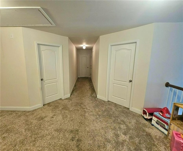 corridor with attic access, carpet, and baseboards