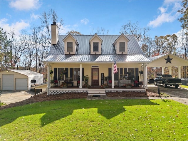 view of front of property featuring covered porch, a garage, an outdoor structure, and a front yard