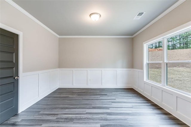 empty room featuring dark wood-type flooring and crown molding