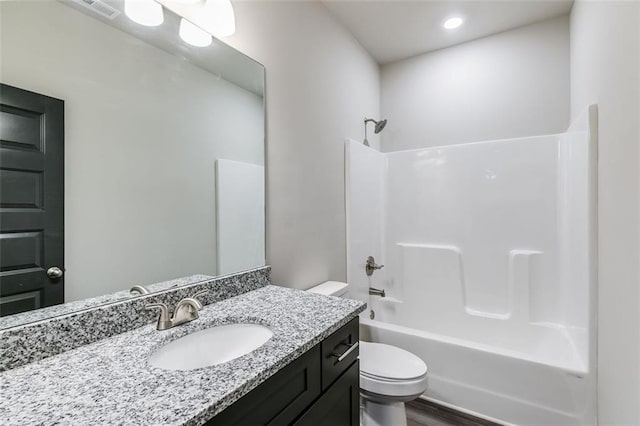 full bathroom with hardwood / wood-style floors, vanity, bathtub / shower combination, and toilet