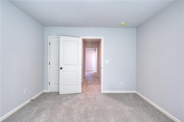 unfurnished bedroom with baseboards, carpet, and attic access