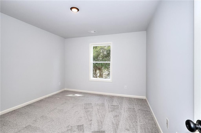 carpeted empty room with visible vents and baseboards