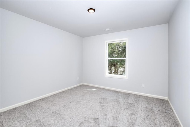 empty room with carpet flooring, baseboards, and visible vents