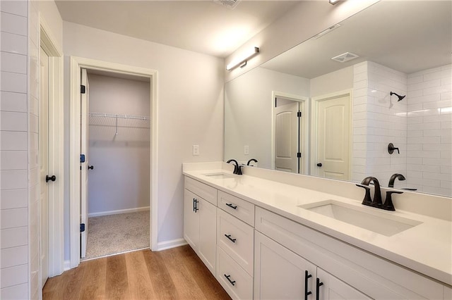 bathroom featuring hardwood / wood-style floors, vanity, and tiled shower