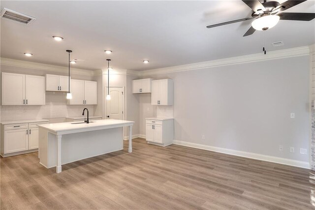 unfurnished living room featuring a stone fireplace, crown molding, light hardwood / wood-style flooring, and ceiling fan