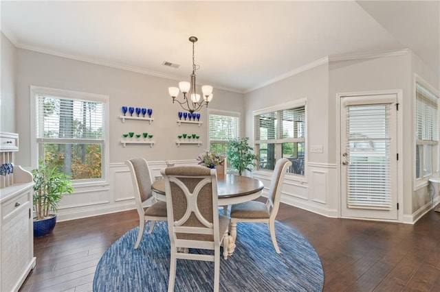 dining area featuring an inviting chandelier, crown molding, a wealth of natural light, and dark hardwood / wood-style floors