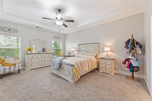 bedroom featuring multiple windows, a raised ceiling, ceiling fan, and carpet flooring