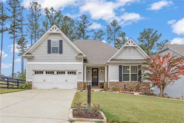 craftsman inspired home featuring a garage and a front lawn