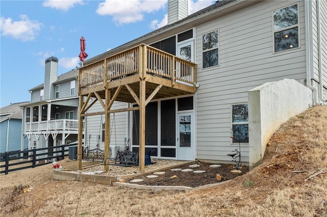 back of property with central AC, a deck, and a sunroom