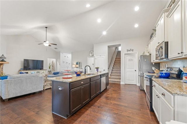 kitchen with sink, white cabinetry, dark brown cabinets, a center island with sink, and stainless steel appliances