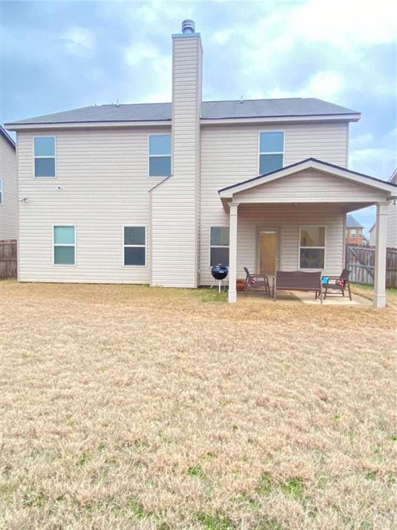 rear view of property with a yard and a patio