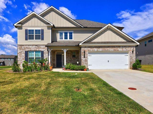 craftsman house with a garage and a front lawn