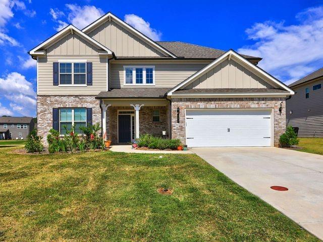 craftsman house with a garage and a front lawn