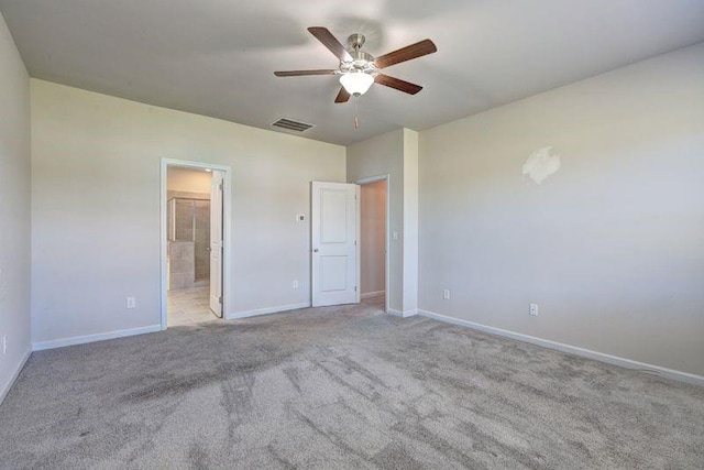 unfurnished bedroom with ceiling fan, ensuite bathroom, and light carpet