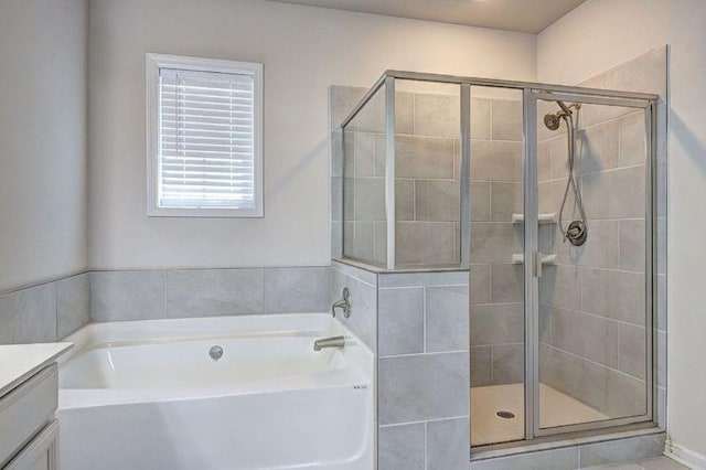 bathroom featuring vanity and independent shower and bath
