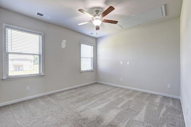 carpeted empty room featuring a wealth of natural light and ceiling fan