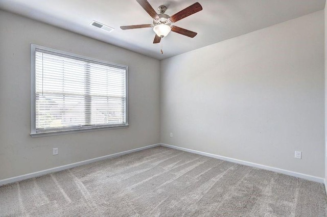 spare room with ceiling fan and light colored carpet