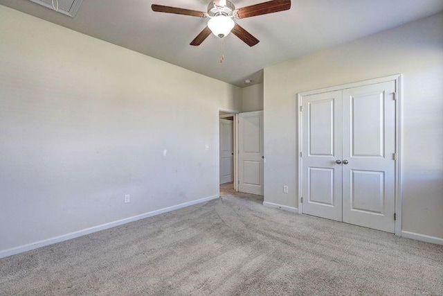 unfurnished bedroom featuring ceiling fan, light colored carpet, and a closet