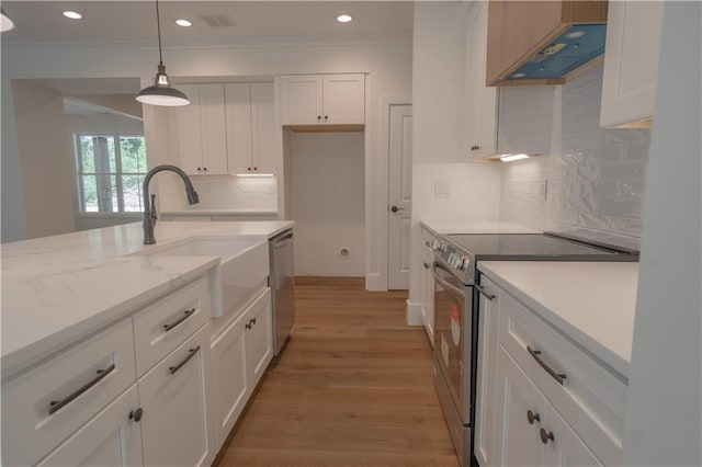 kitchen with light stone counters, decorative light fixtures, white cabinets, and appliances with stainless steel finishes