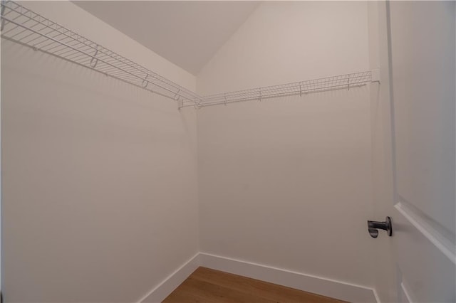 spacious closet featuring vaulted ceiling and hardwood / wood-style floors