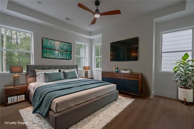 bedroom featuring multiple windows, hardwood / wood-style flooring, and ceiling fan