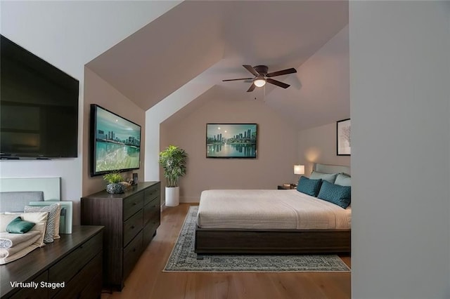 bedroom with ceiling fan, lofted ceiling, and light hardwood / wood-style floors