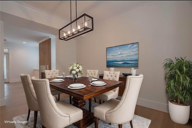 dining room with ornamental molding, wood-type flooring, and a notable chandelier