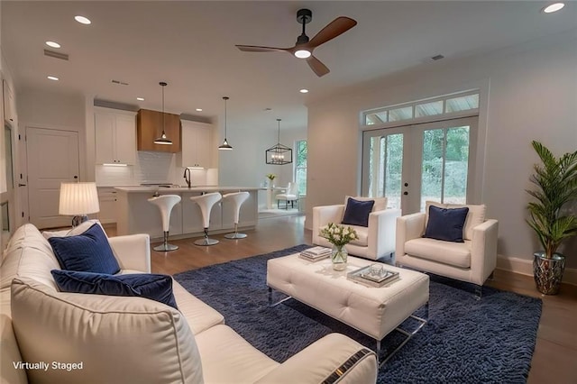 living room with hardwood / wood-style flooring, sink, ceiling fan, and french doors