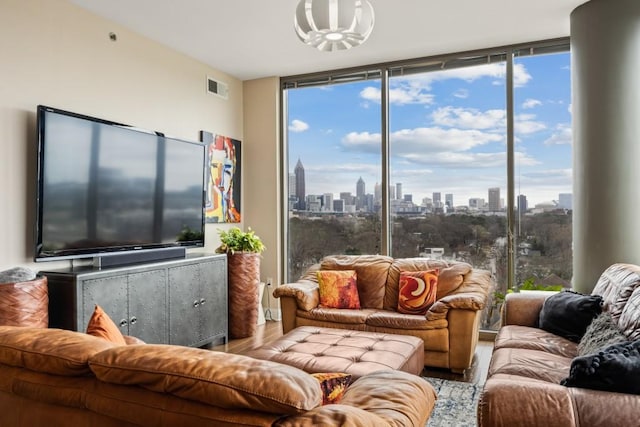 living area featuring visible vents, a wall of windows, and wood finished floors