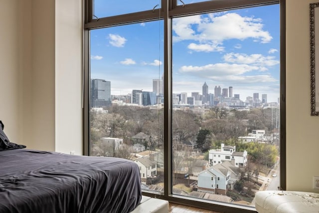 bedroom with floor to ceiling windows and a view of city