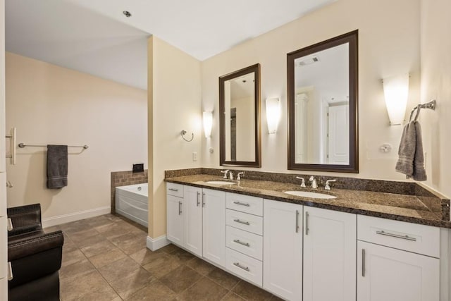 full bathroom with a sink, baseboards, a bath, and double vanity