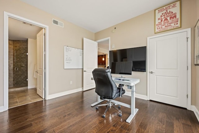 home office with wood finished floors, visible vents, and baseboards