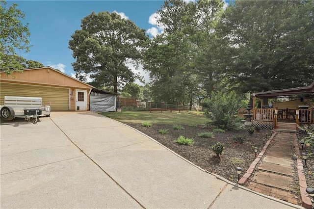 view of yard featuring a garage, an outdoor structure, and a wooden deck