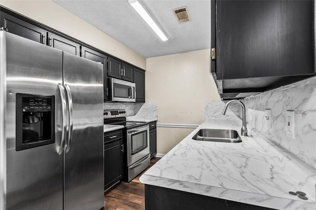 4146 Monclair Dr, Columbus, GA 31907 - kitchen featuring stainless steel appliances, dark cabinets, decorative backsplash, and a textured ceiling