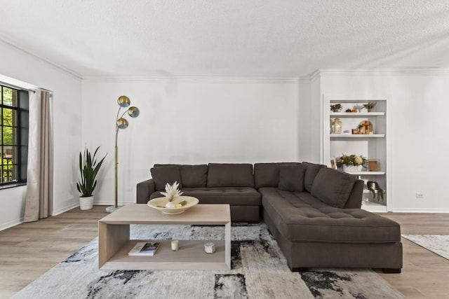 living room featuring a textured ceiling, light hardwood / wood-style flooring, and crown molding