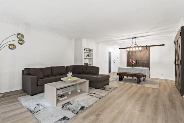 living room with crown molding, a barn door, and wood-type flooring