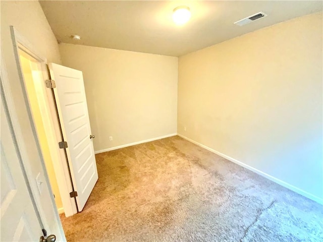 unfurnished room featuring light colored carpet, visible vents, and baseboards