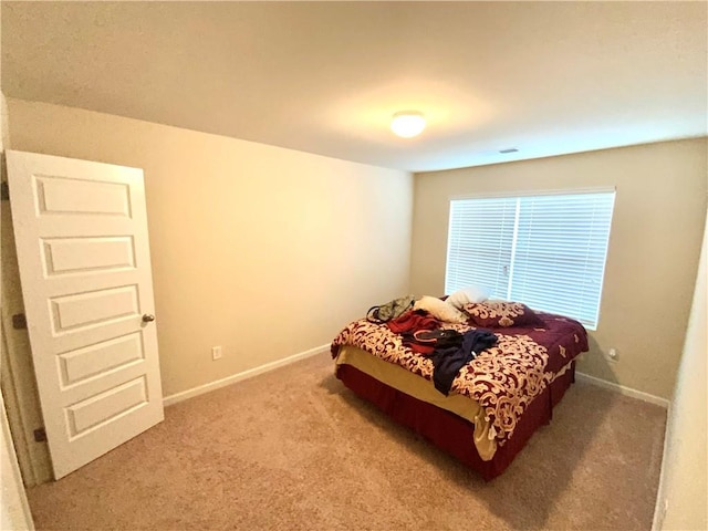 bedroom with baseboards and light colored carpet