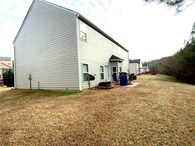 rear view of property featuring a patio area and a lawn