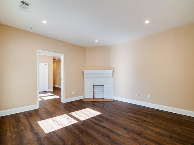 689 Berne St SE, Atlanta, GA 30312 - unfurnished living room with dark wood finished floors, a brick fireplace, and recessed lighting