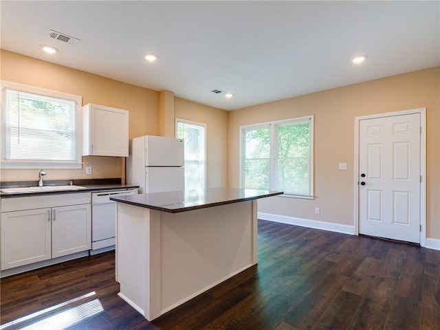 689 Berne St SE, Atlanta, GA 30312 - kitchen featuring white appliances, dark wood finished floors, white cabinetry, dark countertops, and a kitchen island